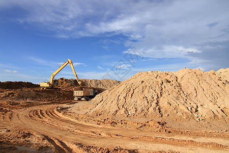 CO2在室外工作时进行挖土作业的挖掘机装载机蓝色天空土壤反铲机械建筑机器车辆挖掘刀刃图片