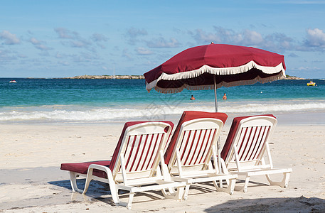 3个沙滩休闲游客和沙上雨伞明信片靠垫三重奏躺椅阳光天堂太阳塑料热带旅行图片