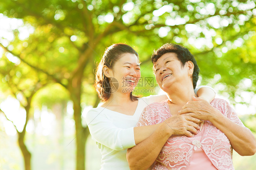 年老母亲和女儿家庭父母公园微笑喜悦女性女孩后代花园乐趣图片