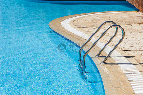 在游泳池中抓铁条梯子太阳反射阳光旅行游客金属栏杆波纹泳池边缘图片