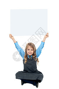 可爱的孩子拿着空白的广告板 在她头顶上图片