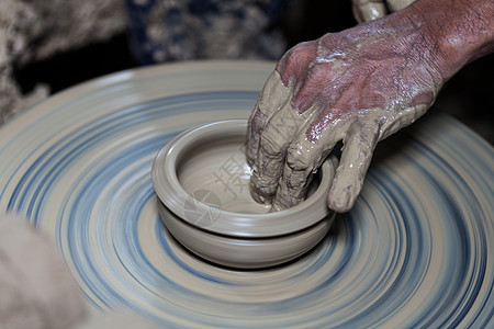 手放在用粘土制成的陶器上艺术家团体风格花瓶陶瓷作坊黏土创造力水壶工艺图片