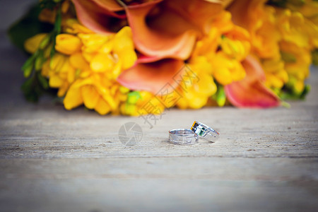结婚戒指和婚礼花束婚姻玫瑰钻石珠宝庆典金属首饰仪式联盟礼物图片