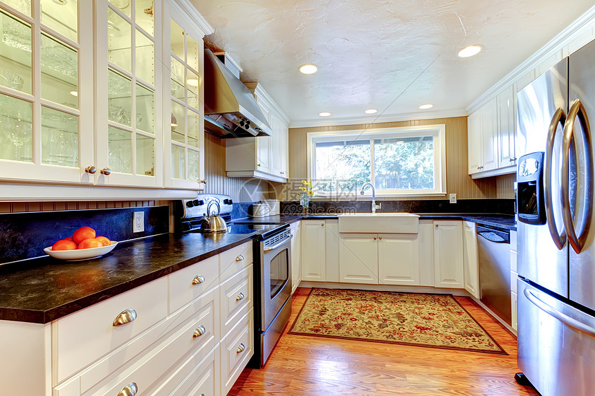 白色厨房内有大水槽和窗户公寓橱柜冰箱家具木头建筑学建筑台面房子硬木图片