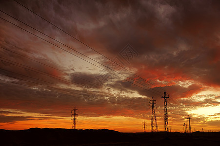在撒哈拉沙漠上闪耀着彩色的白日黑云天空日落辉光沙漠铁塔输电塔晚霞图片