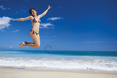女人在海滩上跳跃太阳天堂假期身体旅行天空跑步热带闲暇女性图片