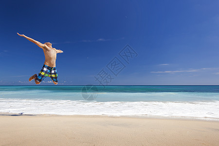 男人在海滩上跳跃棕褐色太阳天堂闲暇成人蓝色热带天空旅行跑步图片