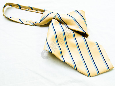 一条在白色背面上被孤立的条纹黄色和蓝色领带服装商业衣领男人衣服丝绸领结男性衬衫项圈图片