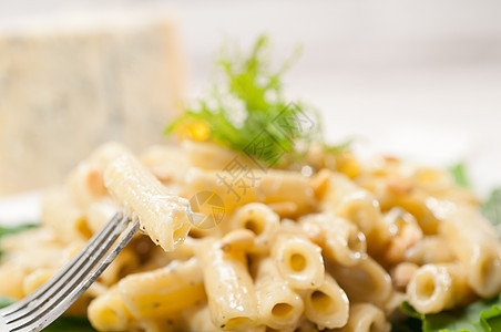 意大利通心粉戈贡佐拉和松子羊乳硬粒产品蔬菜坚果奶油盘子午餐食物蓝色图片