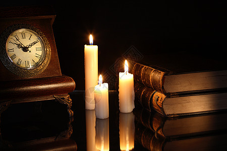 书籍和时钟悲伤回忆照明燃烧灯光灯芯时间记忆悲哀阅读背景图片