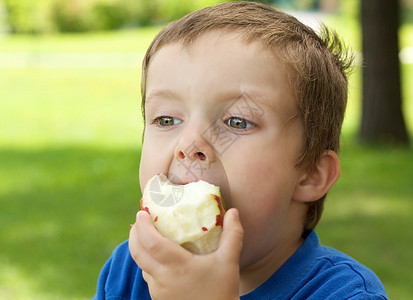 男孩吃苹果红色小吃水果孩子白色食物男生公园男性童年图片