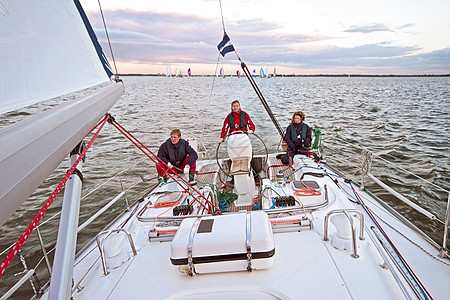 日落时在荷兰IJsselmeer号上航行运动游艇女士男人男性帆船风帆运输图片