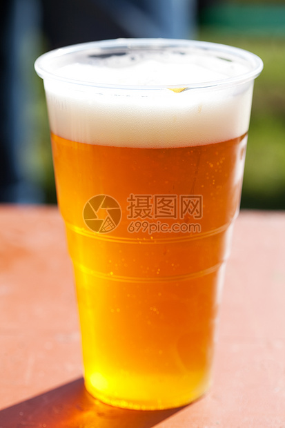 桌上的轻啤酒杯花园酒吧金子派对托盘木头阳光酒精液体餐厅图片