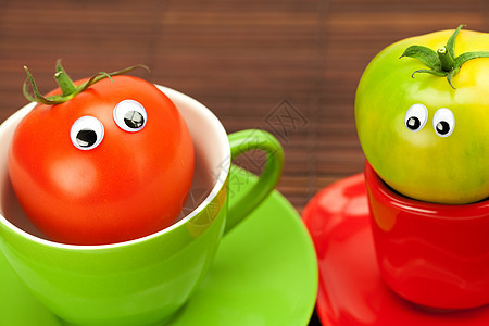 竹垫上杯子里有眼睛的西红柿早餐笑脸用具陶瓷食物木头飞溅菜肴飞碟创造力背景图片
