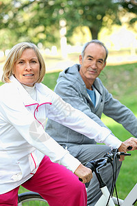 乘坐自行车的老年人踏板场地运动运动裤踪迹女士短裤森林公园粉色图片