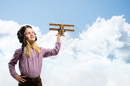 戴头盔驾驶员的女孩玩玩具飞机空军眼镜传单旅行飞行员蓝色空气航空天空童年图片