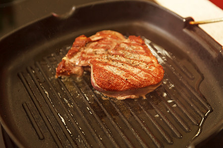 肉片在喷漆板上磨擦猪肉厨师牛扒盘子烹饪食物火炉餐厅平底锅炒锅图片