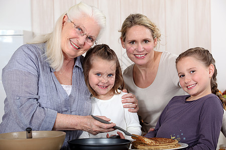 外祖母在女儿和孙子周围做煎饼 环绕儿孙图片