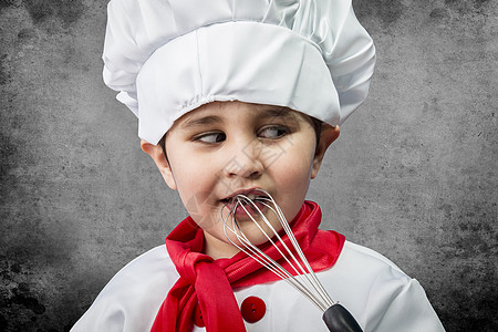 穿制服做饭的小男孩 在旧年背景的游戏里图片
