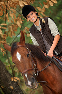 年轻女孩在森林里骑马图片