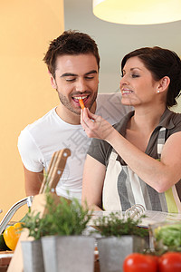 厨房的一对夫妇头发夫妻棕色围裙分拣机沙拉棕褐色条纹西红柿备案图片