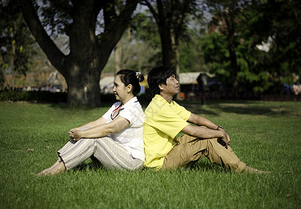 坐在公园地上的一对漂亮的夫妇的肖像妈妈家庭女士野餐母亲快乐幸福爸爸童年草地图片
