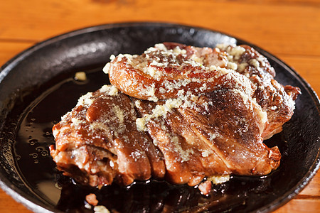 猪腿上涂着蜂蜜和大蒜木头猪肉食物平底锅盘子骨头酸菜美食油炸小腿图片