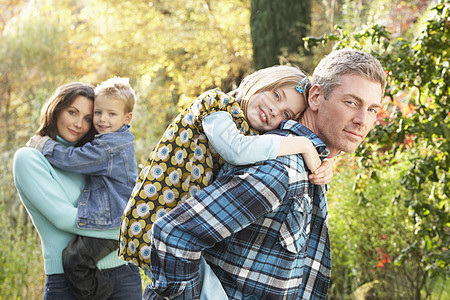 秋季风景中家庭户外群体与父母给予Ch女儿女士花园儿子微笑拥抱男人母亲公园孩子们图片