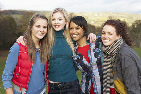秋季风景中的四位青少年女性朋友小组树叶三个人队友女孩朋友们混血女士叶子友谊衣服图片