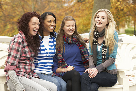 秋天公园四组坐在法官席的四位少女群体朋友们衣服树叶笑声友谊队友四个人微笑公园女性图片
