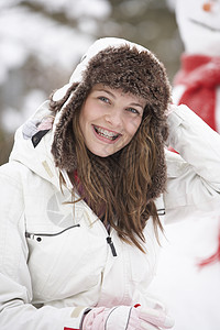 在雪地风景中穿冬衣的少女场景风镜女性青少年帽子微笑下雪围巾笑声寒冷图片