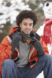 在雪地风景中穿冬衣的男子微笑花园滑雪镜混血天气笑声下雪场景男性寒冷图片