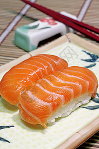 美味的鲑鱼 一串筷子和一块方板图片