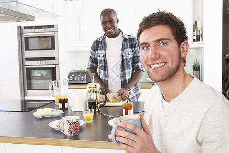 2名青年男子在现代厨房准备早餐图片