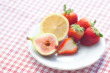 切草莓或柠檬柠檬 无花果和草莓餐具小吃格子水果饮料菜肴织物陶瓷食物盘子背景