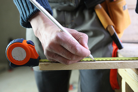 木工在一块木柴上作记号的木匠工艺磁带控制板职业工具工人金属测量铅笔建设者图片
