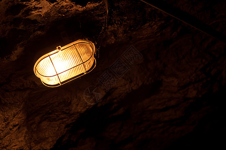 洞穴中的旧电灯矿物水平照片灯泡探洞者石头玻璃矿业黄色工业图片