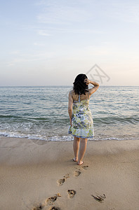 女人尝试水泡沫支撑女士旅行海浪地平线裙子海滩假期海岸图片