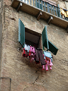 锡耶纳-在绿密闭的窗户下被挂到干燥中的洗涤活动图片