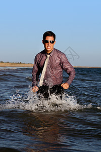 勇敢的商务人士地平线色调海浪套装领带男性海岸线荒野阳光支撑背景图片