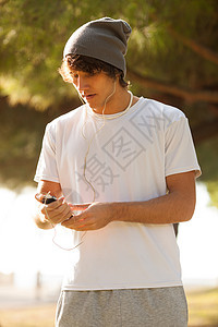 英俊的年轻人在户外咨询电话邮件玩家男人音乐公园背景图片