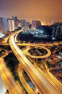 晚上在高速公路上 现代城市的汽车灯光照亮车道速度运输土地建筑交通曲线射线路口运动图片