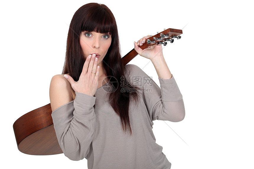 年轻女子用手背着吉他在嘴前携起吉他图片