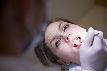牙科诊所有牙医检查牙齿卫生的年轻女医生;图片