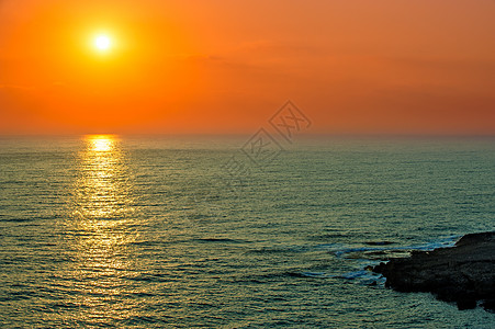日落在海面上黄色橙子日出海岸蓝色阳光红色反射海浪太阳图片