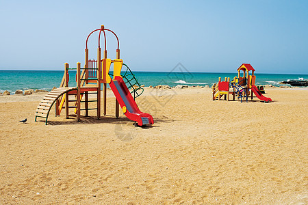 孩子们在海边的游乐场天气阳光海洋公园童年海滩乐趣操场海岸栏杆图片