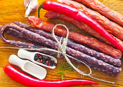木制桌上的香肠和香味香料蔬菜细绳店铺产品小吃油炸市场宏观熏制美食图片