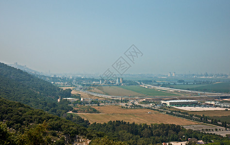 从卡梅尔山查看高原岩石苔藓海法峡谷树木背景图片