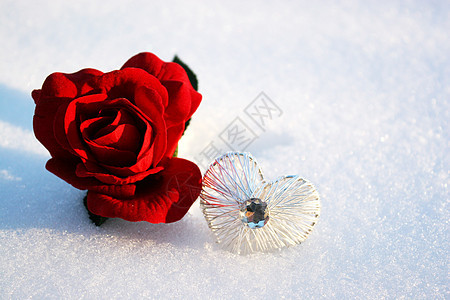 红玫瑰在雪中降下 冬日带着水晶的心图片