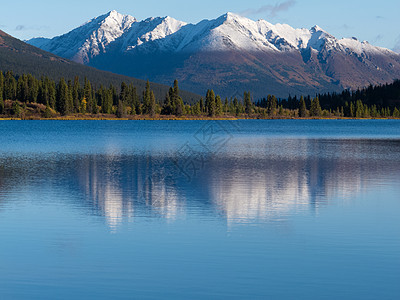 育空湖莱皮湖上的雪地山的反射图片